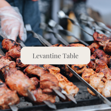 Grilled skewers of marinated meat on a barbecue with a caption "Levantine Table."